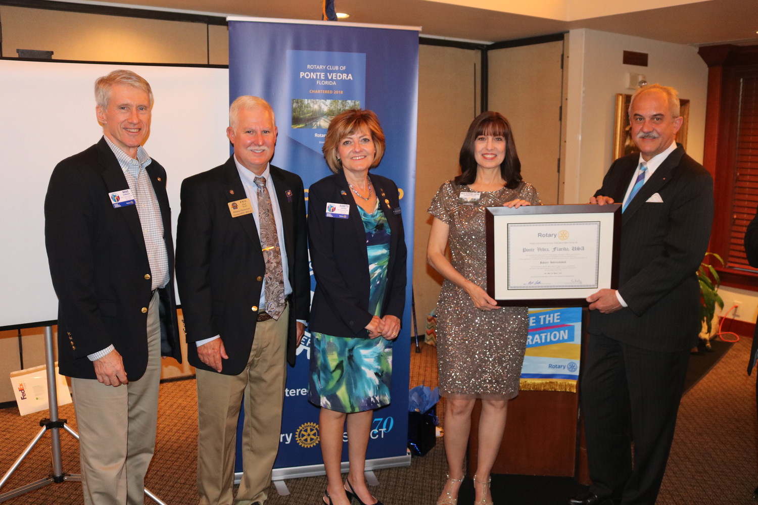 Rotary Club of Ponte Vedra President Kelly Altosino-Sastre (second from right) receives the official charter from Rotary International, presented by Rotary District 6970 Governor Nominee Mike Darragh (from left), Past District Governor Fel Lee, 2018-19 District Governor-Elect Jeanette Loftus and Rotary International Director David Stovall, at a special chartering ceremony held April 25 at Marsh Landing Country Club.